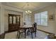 Elegant dining room with crown molding, a chandelier, and a large window creating a sophisticated atmosphere at 16524 Palisades Commons Dr, Charlotte, NC 28278