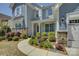 Landscaped front yard with stone accents, a walkway, and well-maintained flowerbeds leading to the charming entrance at 16524 Palisades Commons Dr, Charlotte, NC 28278