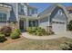 Inviting home exterior showcases a manicured lawn, stone accents, and a charming covered porch with elegant details at 16524 Palisades Commons Dr, Charlotte, NC 28278