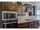 Close up of the dark wood kitchen cabinets, stainless appliances, and stone counter tops at 16524 Palisades Commons Dr, Charlotte, NC 28278