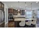 Kitchen boasts dark wood cabinets, stone counters, stainless appliances, and a breakfast nook at 16524 Palisades Commons Dr, Charlotte, NC 28278