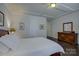 Main bedroom with hardwood floors, tray ceiling, dresser, and white linens at 16524 Palisades Commons Dr, Charlotte, NC 28278