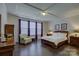 Large main bedroom with hardwood floors, tray ceiling, two side tables, and sitting chair at 16524 Palisades Commons Dr, Charlotte, NC 28278