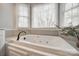This bright bathroom features a garden tub beneath a set of bright windows with privacy blinds at 2095 Westridge Dr, Rock Hill, SC 29732