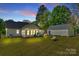 Backyard with cozy white house, glowing with warm light and a star-filled twilight sky at 2175 Highwood Rd, Rock Hill, SC 29732
