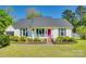 Charming single-story home boasts a manicured lawn, cheerful pink front door, and inviting front porch with seating at 2175 Highwood Rd, Rock Hill, SC 29732