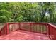 View of a spacious red wood deck surrounded by lush greenery, perfect for outdoor relaxation and entertainment at 2325 Sanders Ave, Charlotte, NC 28216