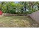 The expansive backyard, enclosed by a wooden fence, offers a private outdoor retreat with mature trees at 2325 Sanders Ave, Charlotte, NC 28216