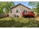 The backyard boasts a red deck, mature trees, and ample green space, perfect for outdoor activities at 2325 Sanders Ave, Charlotte, NC 28216