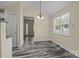Sunny dining room with gray flooring, a modern chandelier, and a bright window at 2325 Sanders Ave, Charlotte, NC 28216