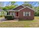 Charming brick home featuring a well-kept lawn and a welcoming red front door at 2325 Sanders Ave, Charlotte, NC 28216