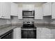 Updated kitchen with stainless steel appliances, granite countertops, white cabinetry, and a stylish backsplash at 2325 Sanders Ave, Charlotte, NC 28216