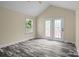 Bright living room with vaulted ceilings, new floors, and double doors to outside at 2325 Sanders Ave, Charlotte, NC 28216