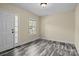 Bright living room with modern gray flooring, fresh paint, and a stained glass side window by the entrance at 2325 Sanders Ave, Charlotte, NC 28216