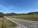 Expansive grassy fields meet rolling hills, creating a serene countryside view from the roadside at 236 Bowmans Cutover Rd, Taylorsville, NC 28681