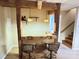 Rustic basement bar with wood beams, glass countertop, stools, and decorative skull at 245 Clontz Hill Rd, Troutman, NC 28166