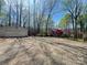 Gravel driveway leading to a detached garage and home nestled among mature trees, ensuring privacy at 245 Clontz Hill Rd, Troutman, NC 28166