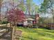 A picturesque house with a brick chimney, inviting porch, and colorful trees in a peaceful yard at 245 Clontz Hill Rd, Troutman, NC 28166