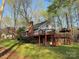 Back of home featuring an elevated deck with gazebo overlooking a lush lawn and wooded lot at 245 Clontz Hill Rd, Troutman, NC 28166