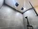 Modern shower features gray tile, dual shower heads, and a handheld shower head at 245 Clontz Hill Rd, Troutman, NC 28166