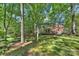 Beautiful backyard with a pond, a lawn, and a view of the house and surrounding trees at 2605 Winding Oak Dr, Charlotte, NC 28270