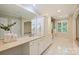 Bright bathroom with double vanity, arched doorway, and white tile flooring at 2605 Winding Oak Dr, Charlotte, NC 28270
