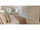 Serene bedroom featuring a king bed with decorative pillows, shuttered windows, and cozy sitting chairs at 2605 Winding Oak Dr, Charlotte, NC 28270