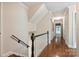 Hallway showcasing hardwood floors, traditional wainscoting, and a staircase with a dark handrail at 2605 Winding Oak Dr, Charlotte, NC 28270