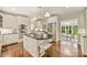 Well-lit kitchen with white cabinetry, stainless steel appliances, island with seating, and hardwood flooring at 2605 Winding Oak Dr, Charlotte, NC 28270