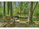 Backyard pond with seating surrounded by trees and manicured lawn at 2605 Winding Oak Dr, Charlotte, NC 28270