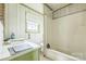 Bathroom with green trim, a sink, toilet, and bathtub with a white shower curtain at 2705 Robinson Rd, Newton, NC 28658