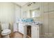 Bathroom with water bottles sitting on a white marbled countertop next to a sink and toilet at 2705 Robinson Rd, Newton, NC 28658