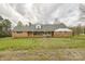 Traditional brick ranch home with a covered front porch and mature landscaping on a cloudy day at 2705 Robinson Rd, Newton, NC 28658