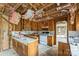 Wooden cabinets and white appliances in a kitchen featuring exposed framework and insulation at 2705 Robinson Rd, Newton, NC 28658