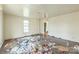 Cluttered room with hardwood floors, window, and debris, showing a space in need of renovation at 303 E Fisher St, Salisbury, NC 28144
