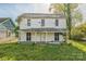 Two-story white home with a covered porch and overgrown landscaping at 303 E Fisher St, Salisbury, NC 28144