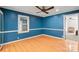 Bright bedroom featuring a ceiling fan, painted blue walls, and hardwood floors at 317 S Lineberry St, Troy, NC 27371