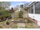 Backyard view of greenhouse exterior with brick siding home at 317 S Lineberry St, Troy, NC 27371
