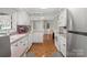 A functional kitchen with white cabinetry, wood floors, and abundant natural light at 317 S Lineberry St, Troy, NC 27371