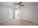 Bedroom features neutral carpet, ceiling fan, closet, and entry door at 3791 Richard St, Claremont, NC 28610
