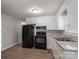 The kitchen features white cabinetry and a black appliance suite at 3791 Richard St, Claremont, NC 28610