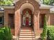 Charming brick front entrance with a welcoming red door and manicured landscaping at 3964 Deer Run Ne Dr, Conover, NC 28613
