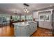 Bright kitchen with white cabinets, a center island with a cooktop, and an adjacent dining area at 3964 Deer Run Ne Dr, Conover, NC 28613