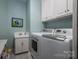 Laundry room featuring a modern washer and dryer, sink, and storage cabinets at 3964 Deer Run Ne Dr, Conover, NC 28613