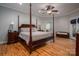 Main bedroom featuring hardwood floors, a canopy bed, ceiling fan, and ensuite bathroom at 3964 Deer Run Ne Dr, Conover, NC 28613