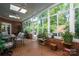Bright sunroom featuring brick flooring and walls, glass windows and doors, and ceiling fans at 3964 Deer Run Ne Dr, Conover, NC 28613