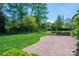 Lush backyard featuring a brick patio, manicured lawn, and mature trees at 418 3Rd Ne St, Hickory, NC 28601