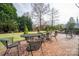 Serene backyard featuring a brick patio with outdoor seating, a grassy lawn, and mature trees at 418 3Rd Ne St, Hickory, NC 28601