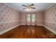 Large empty bedroom with hardwood flooring, floral wallpaper, and natural light at 418 3Rd Ne St, Hickory, NC 28601