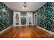 Stylish bedroom with floral wallpaper, hardwood floors, and natural light from large windows at 418 3Rd Ne St, Hickory, NC 28601